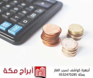 آلة حاسبة بجانب عملات معدنية توضح تكلفة تركيب أجهزة كواشف تسرب الغاز في مكة.